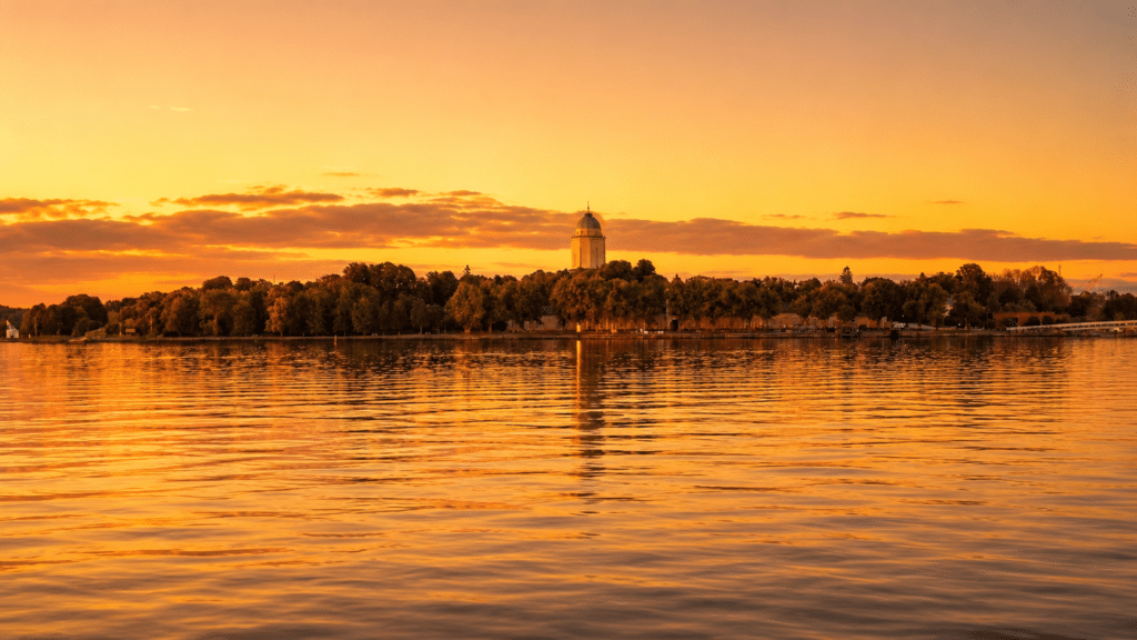 Suomenlinna church tower silhouetted against a warm golden hour sky
