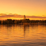 Suomenlinna church tower silhouetted against a warm golden hour sky