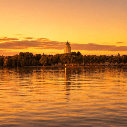 Suomenlinna church tower silhouetted against a warm golden hour sky